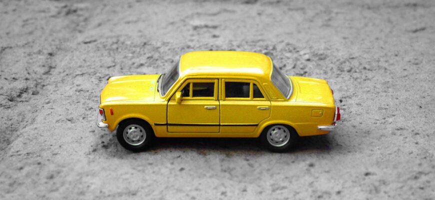 yellow sedan die-cast on gravel